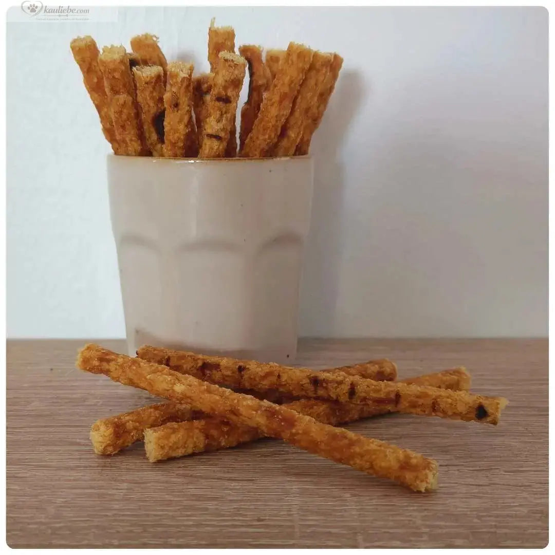 Hähnchensticks von NANDOO in 250g Packung, knusprige Hähnchenfleischsticks auf einem Teller.